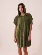 Mulher vestindo PONCHO CURTO CANELADO - VERDE da marca Greenish com capuz e bolso canguru, ideal para frio e esportes aquáticos.