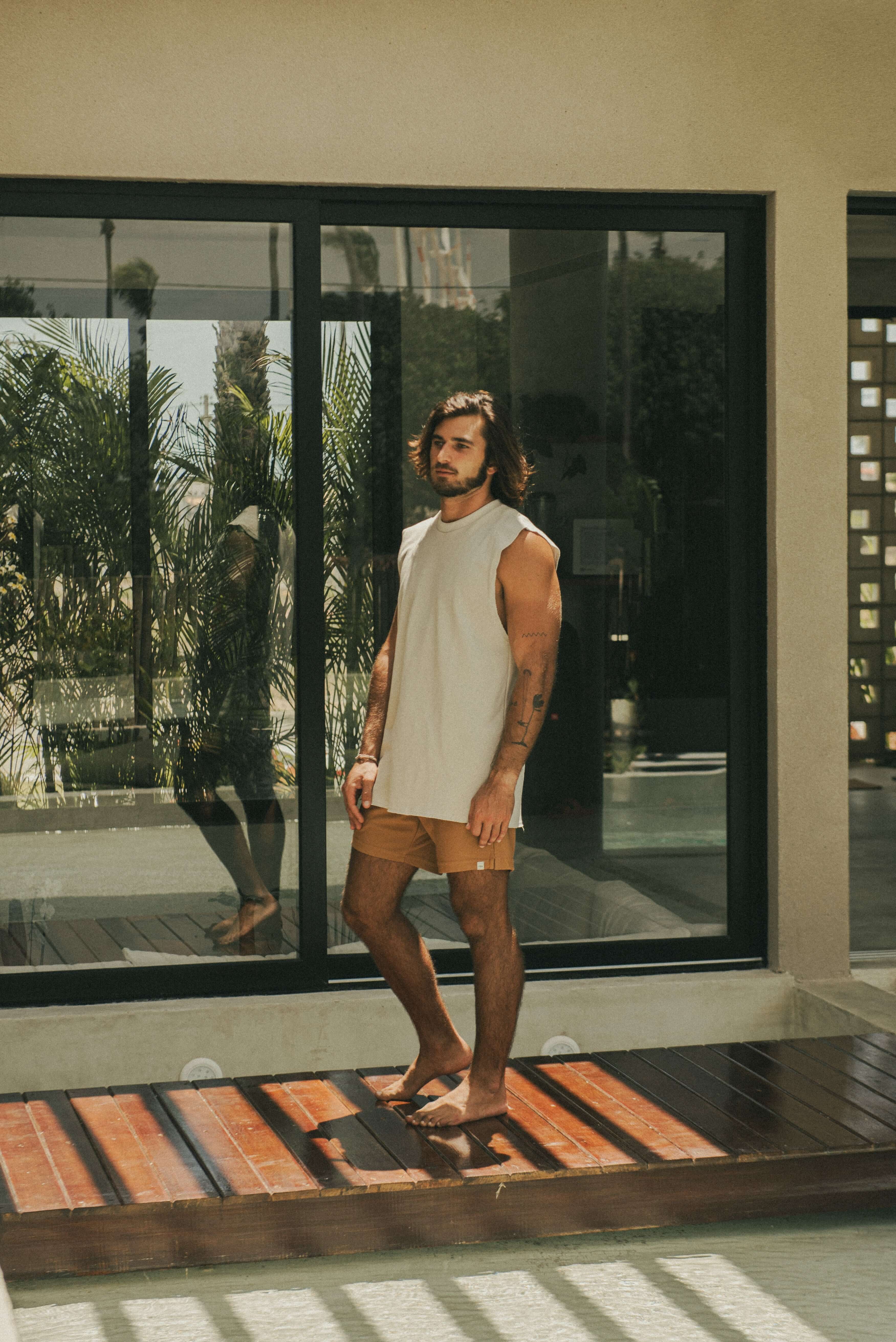 Homem usando Regata Larga Waves - Bege da marca Greenish em ambiente moderno.