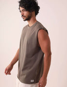 Homem vestindo REGATA LARGA WAVES - VERDE ESCURO da marca Greenish, regata de algodão com modelagem larga e gola ribana, ideal para atividades ao ar livre.