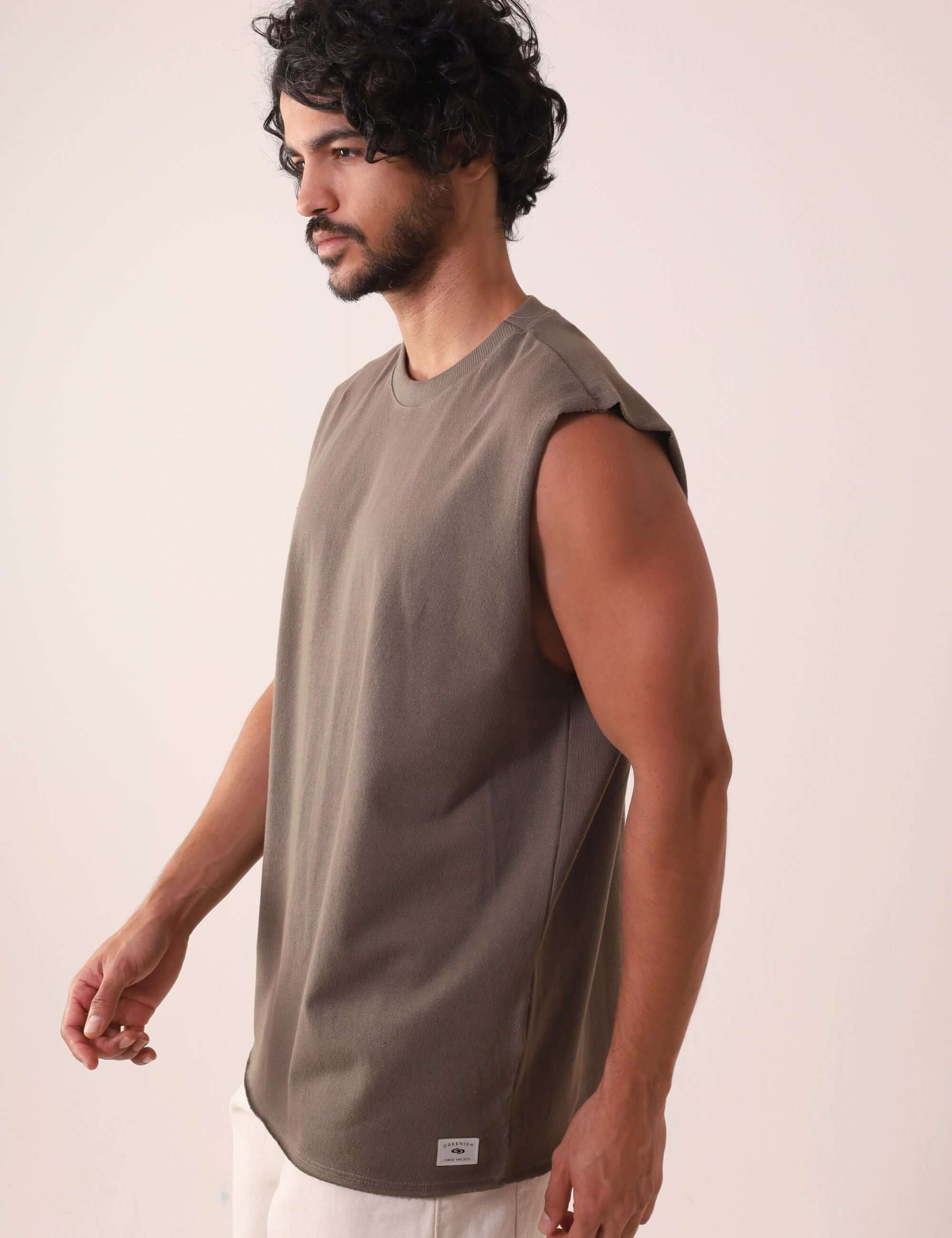 Homem vestindo REGATA LARGA WAVES - VERDE ESCURO da marca Greenish, regata de algodão com modelagem larga e gola ribana, ideal para atividades ao ar livre.