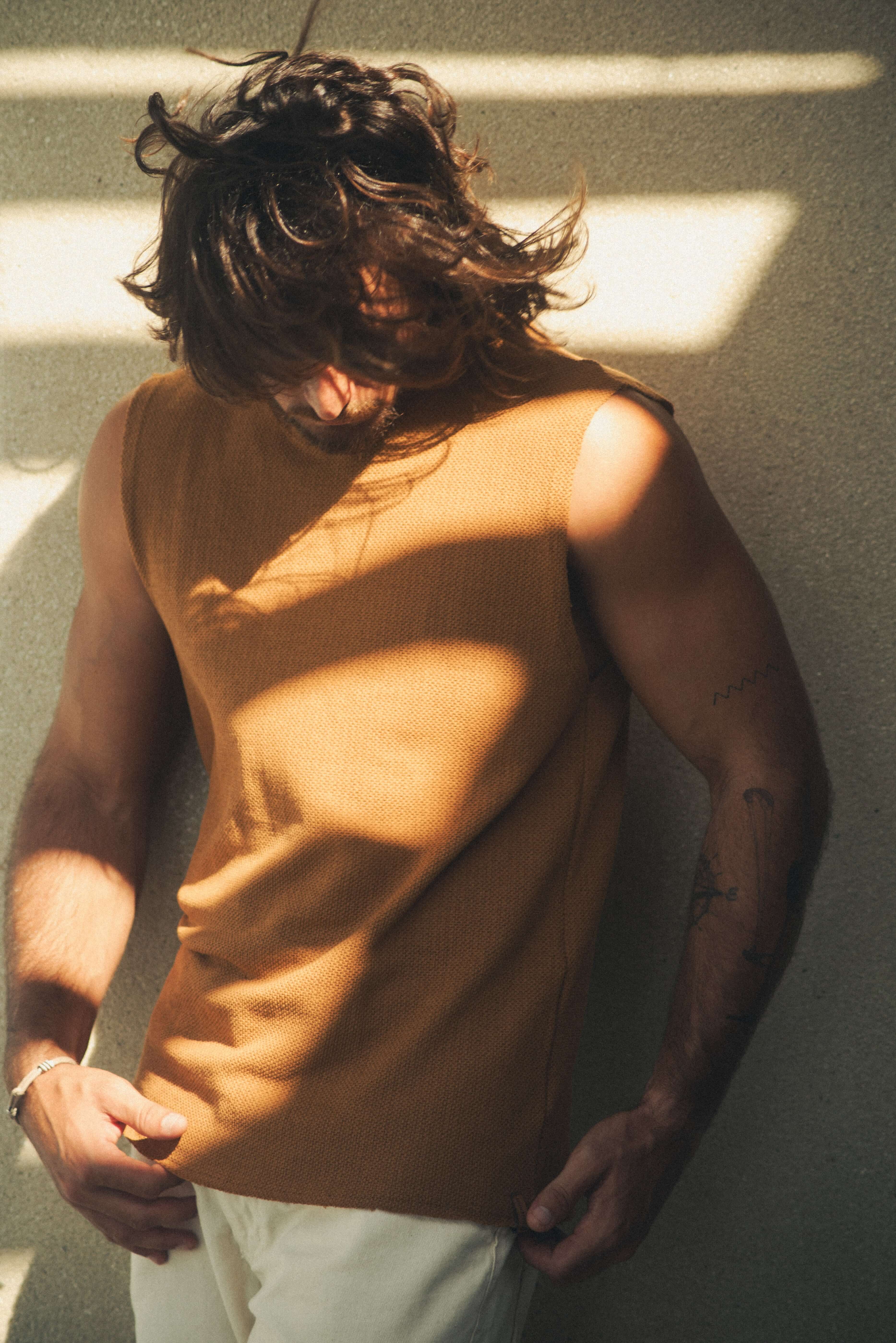 Homem usando REGATA MARÉ - CAQUI da Greenish, com modelagem ampla e confortável, ideal para dias de sol e liberdade. Malha Heritage rústica.