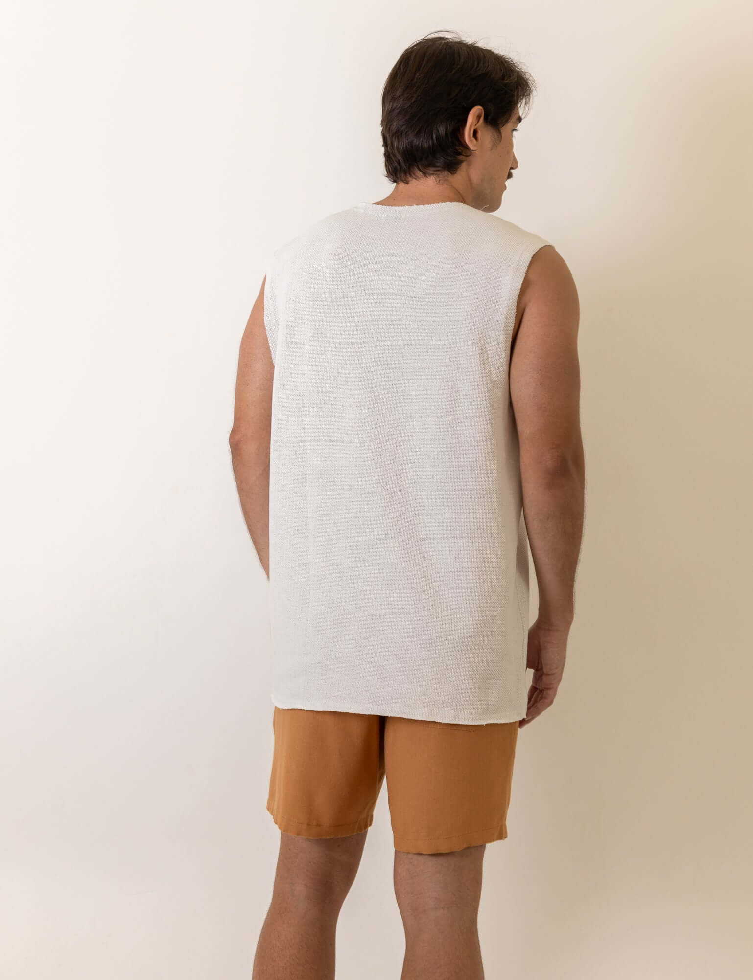 Greenish Regata Maré - Off White: A model wearing a minimalist, comfortable sleeveless shirt with a subtle side label detail.