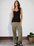 Modelo usando blusa preta Isla da Greenish com calça larga, destacando conforto e estilo.