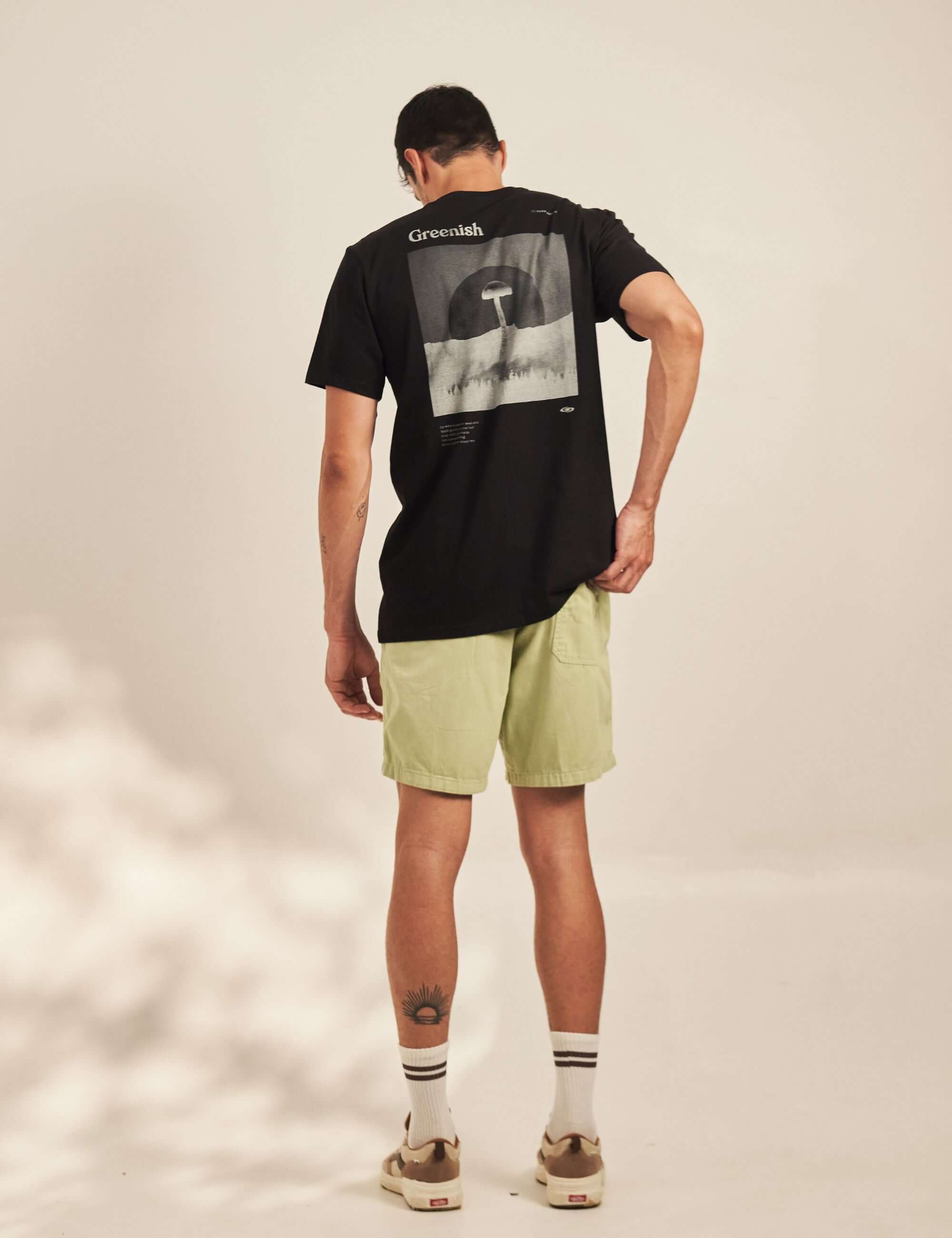 Modelo vestindo Camiseta Wild Mushroom - Preto da marca Greenish, com estampa nas costas e toque natural em meia malha 100% algodão.