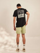 Modelo vestindo Camiseta Wild Mushroom - Preto da marca Greenish, com estampa nas costas e toque natural em meia malha 100% algodão.