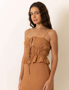 Mulher usando Blusa Lille - Bege da Greenish, com caimento romântico e alcinhas reguláveis para um ajuste perfeito.