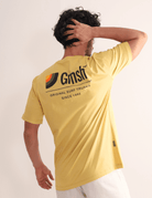 Homem vestindo camiseta Greenish amarela com estampa Surf Trunks Series, destacando estilo confortável e inspirado no lifestyle litorâneo.