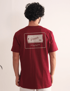 Camiseta Surfboard Wax Scraper bordo da Greenish, com estampa inspirada no surf, caimento confortável e toque macio nas costas.