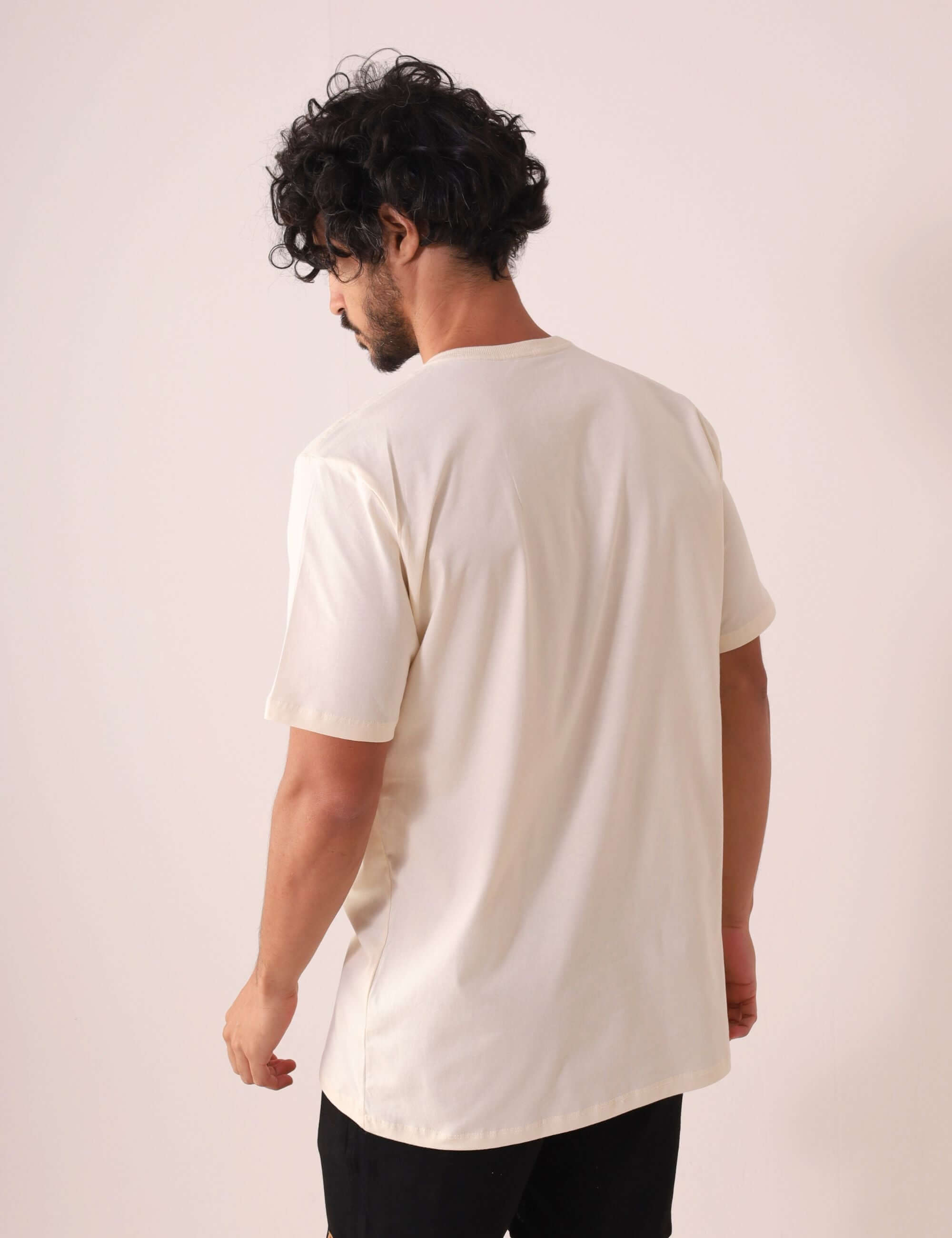 Homem vestindo a Greenish CAMISETA TRADICIONAL BASIC - NATURAL, feita de algodão sustentável, versátil e confortável para o dia a dia.