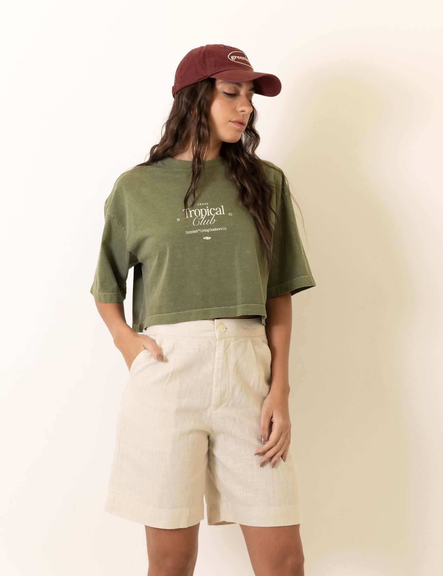 Modelo vestindo camiseta Greenish Cropped Oversized Stone Tropical Club - Verde, com estampa tropical, estilo vintage e toque macio.