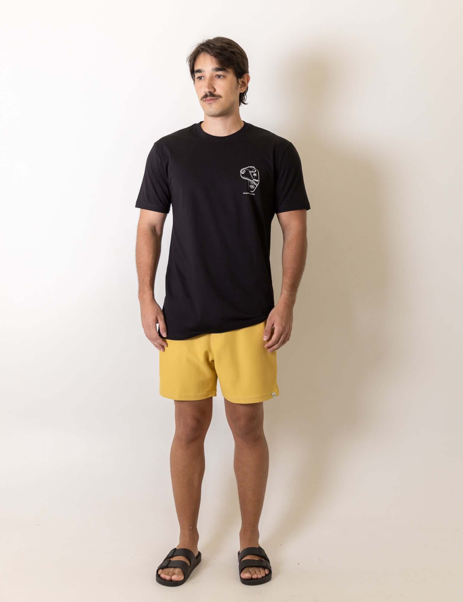 Modelo vestindo Camiseta Fin Key - Preto da marca Greenish com design vintage inspirado no surf e bordado no peito.