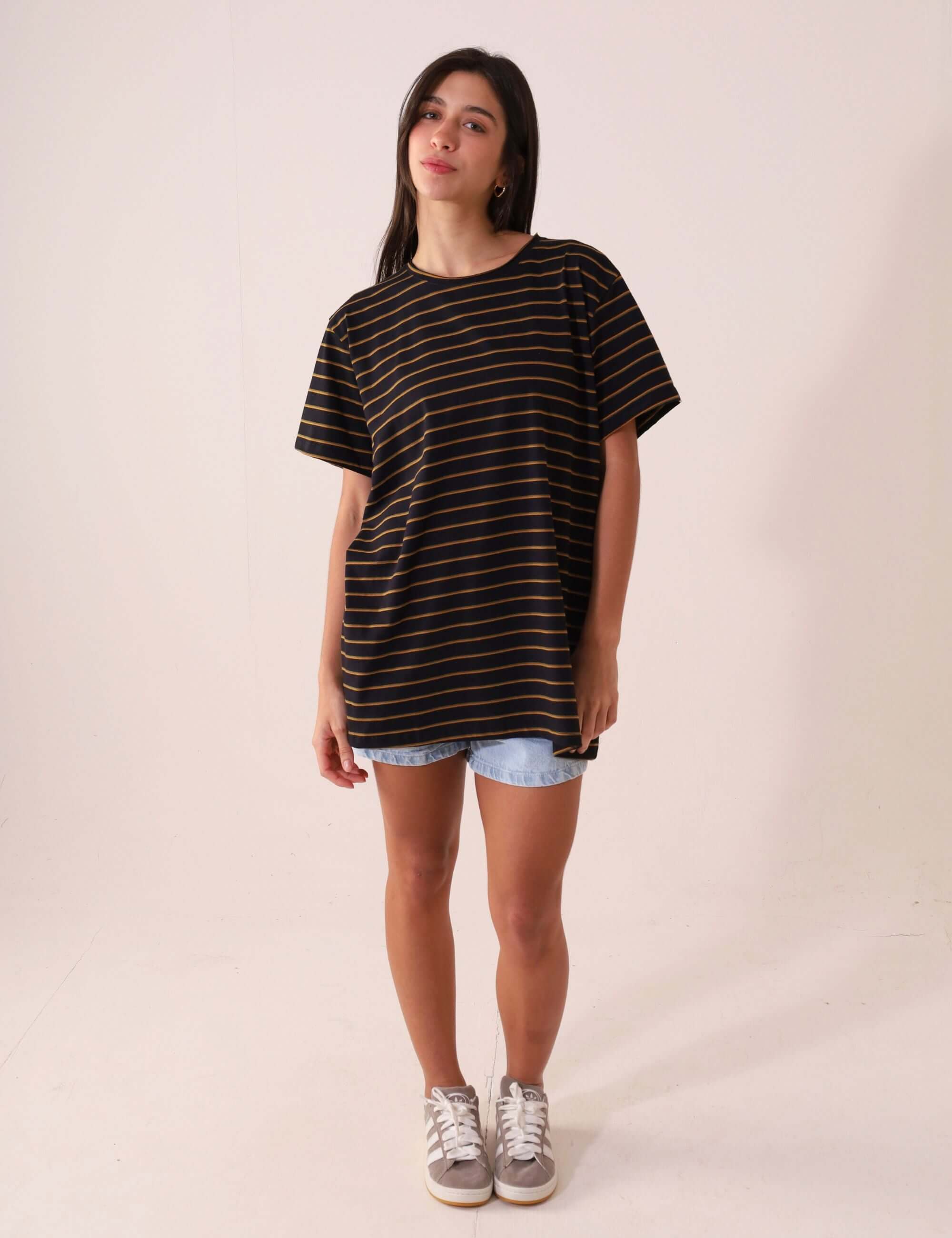 Modelo vestindo CAMISETA NAUTIC - PRETO da Greenish, maxi camiseta listrada de cânhamo e algodão, estilo amplo e confortável, visual clean e natural.