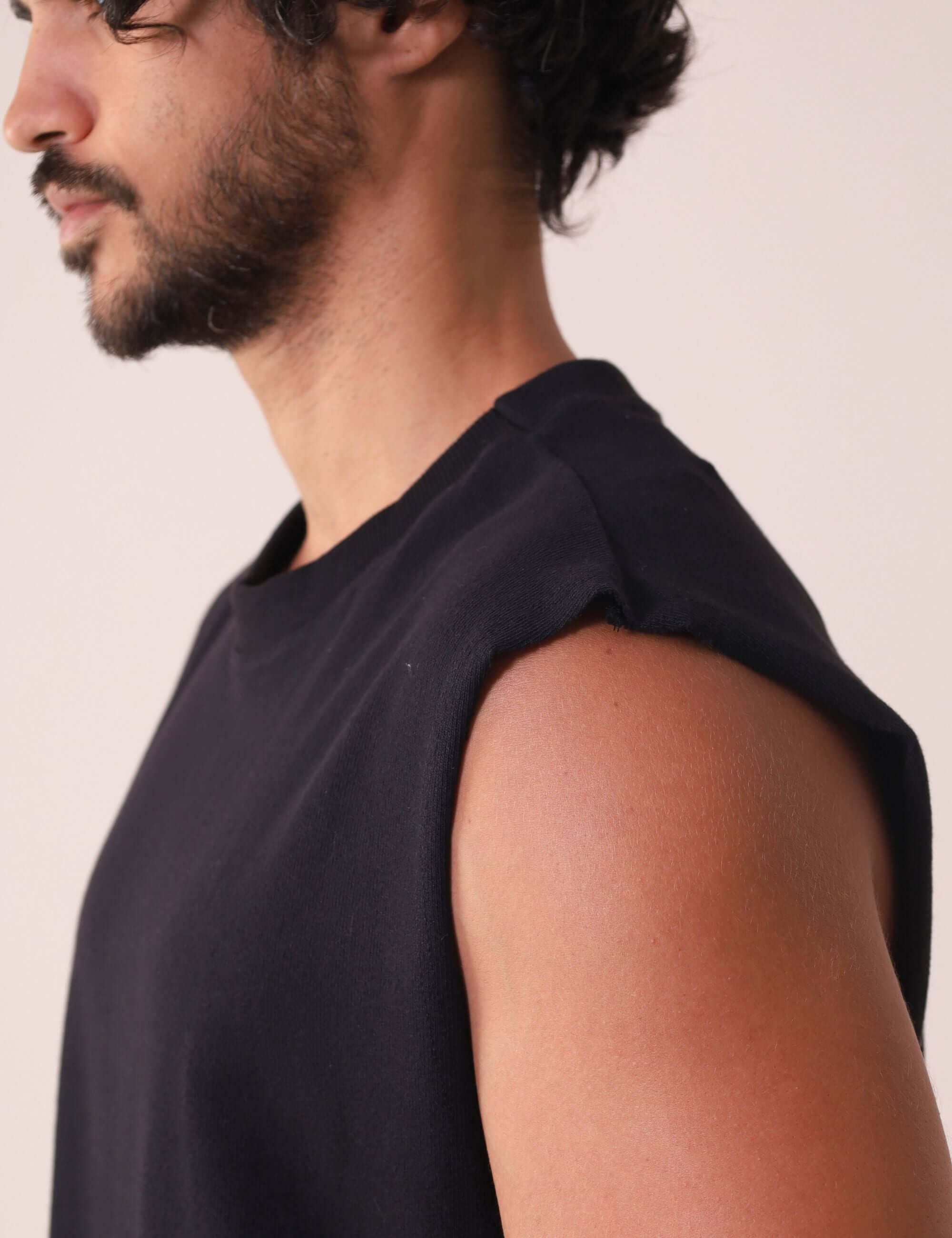 Modelo vestindo a REGATA LARGA WAVES - PRETO da Greenish, em malha 100% algodão, com gola ribana de 6 cm, ideal para dias ao ar livre.