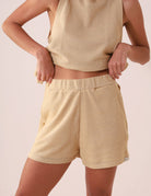 Short feminino bege Greenish, modelo SHORT FUTURE - BEGE, com cós elástico e bolsos laterais, ideal para lazer e conforto.