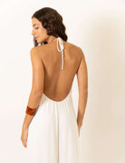 Mulher usa Macacão Frente Única Rustic - Off White da Greenish, com decote nas costas e toque rústico, ideal para dias ensolarados.