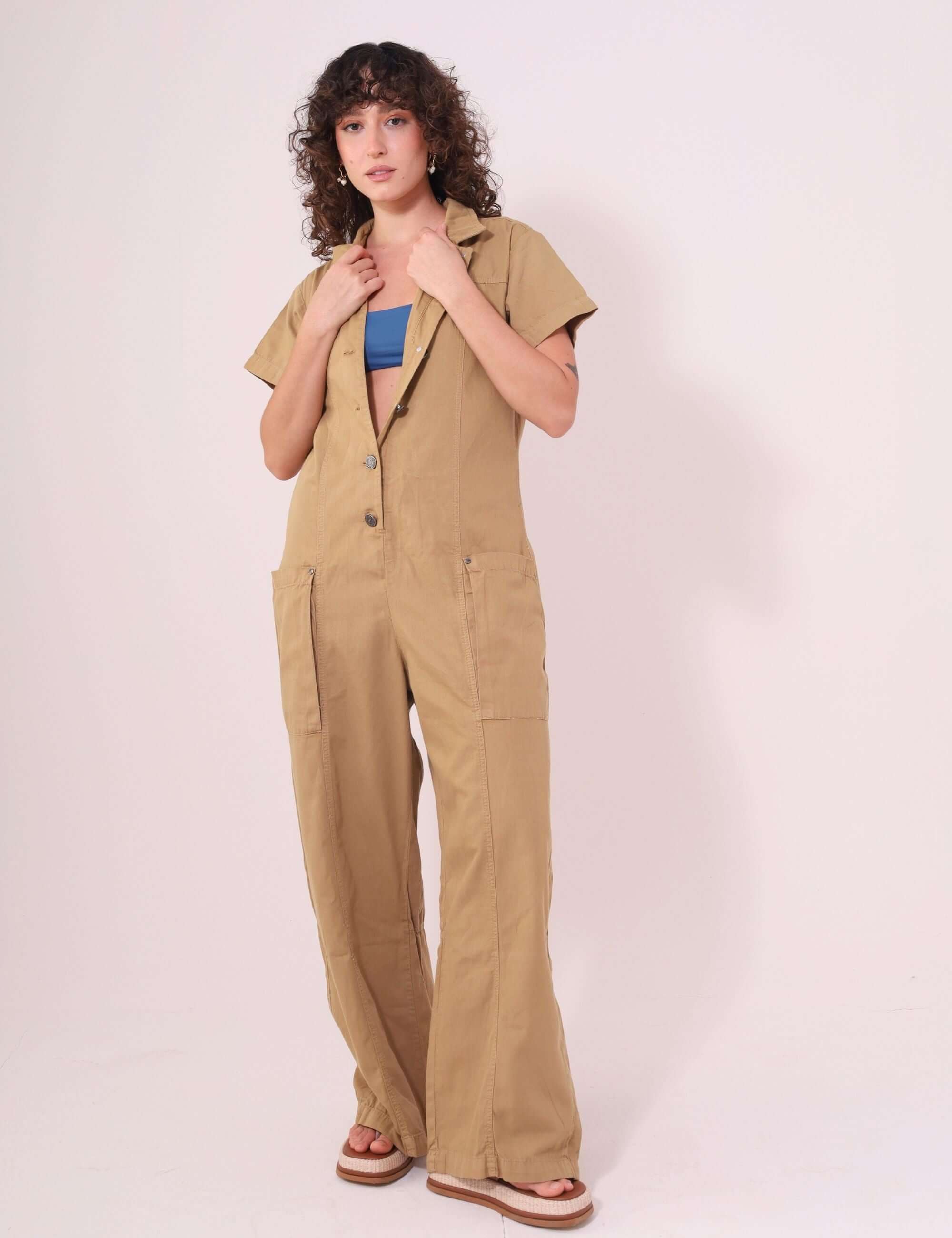 Mulher vestindo Macacão Ivy Bege da Greenish, em sarja 100% algodão, com mangas, gola estruturada e fechamento frontal com botões.
