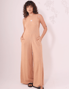  Mulher vestindo Macacão Lais Laranja com decote em V nas costas da Greenish, estilo leve e conforto para o verão.