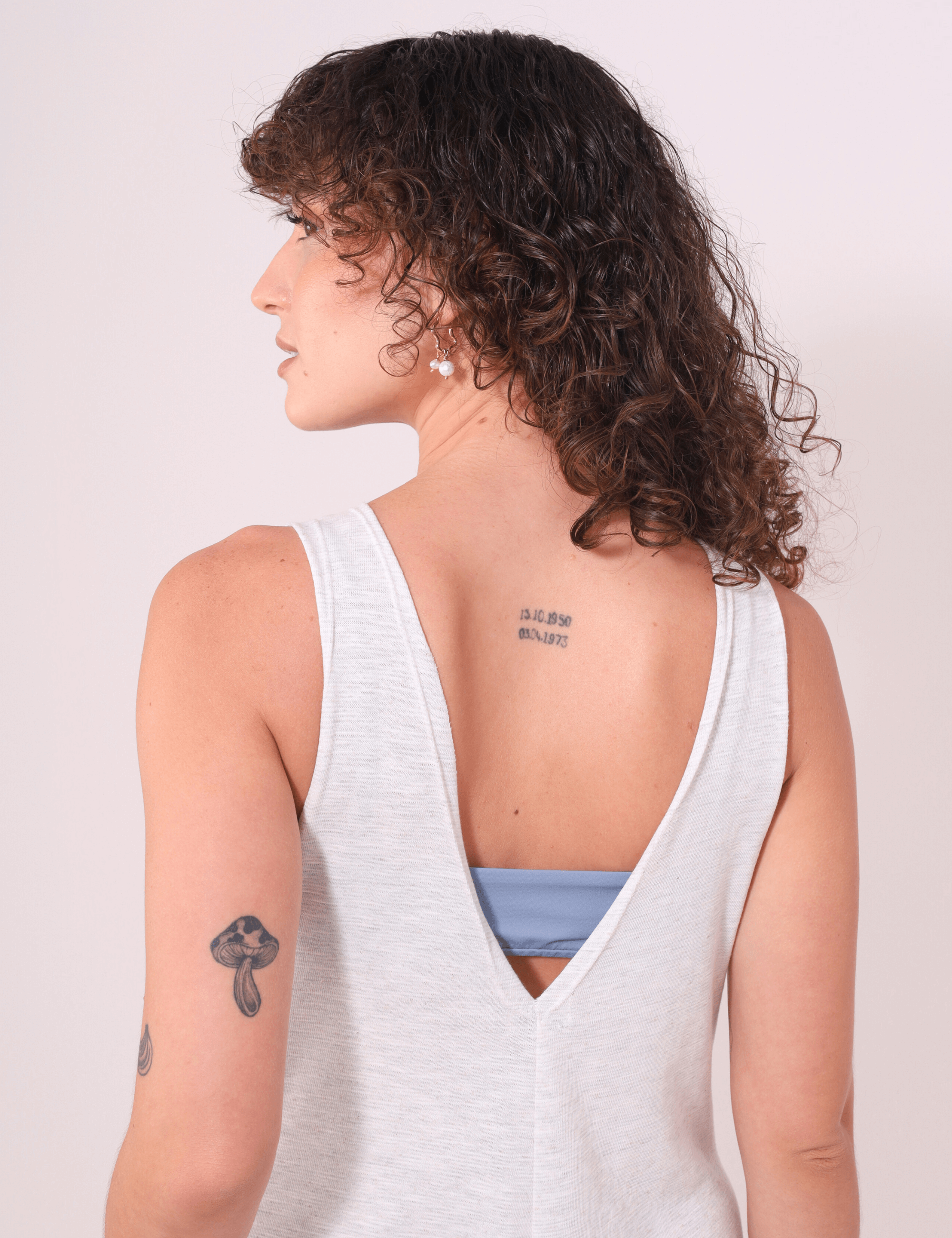 Mulher vestindo Macacão Lais Natural da Greenish, com decote em V nas costas, destacando o estilo leve e conforto do verão.