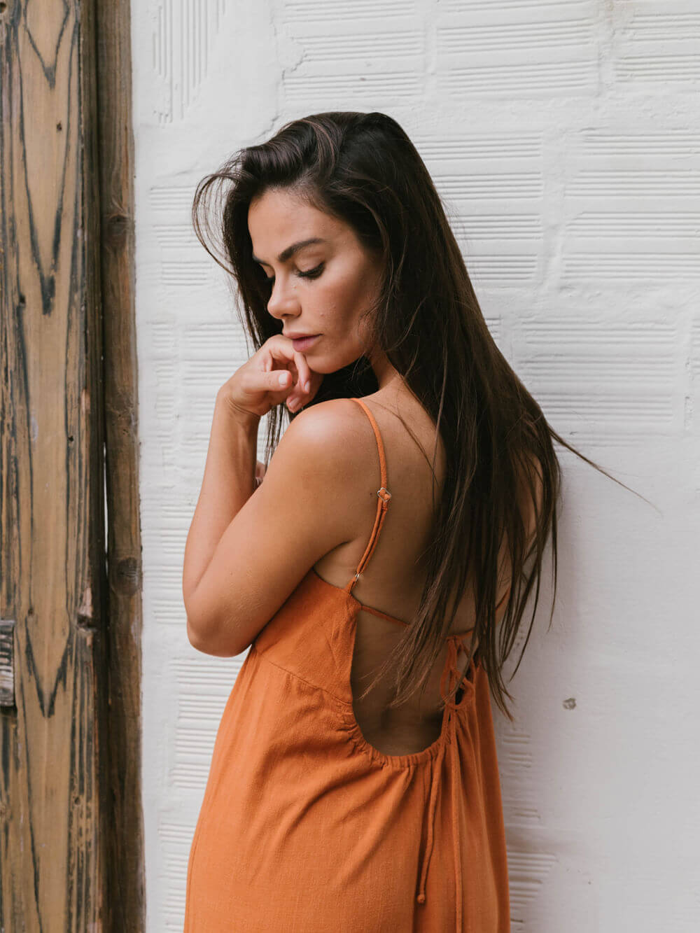 Modelo usando o macacão Mabel laranja da Greenish, com decote nas costas e alças reguláveis, perfeito para o verão.