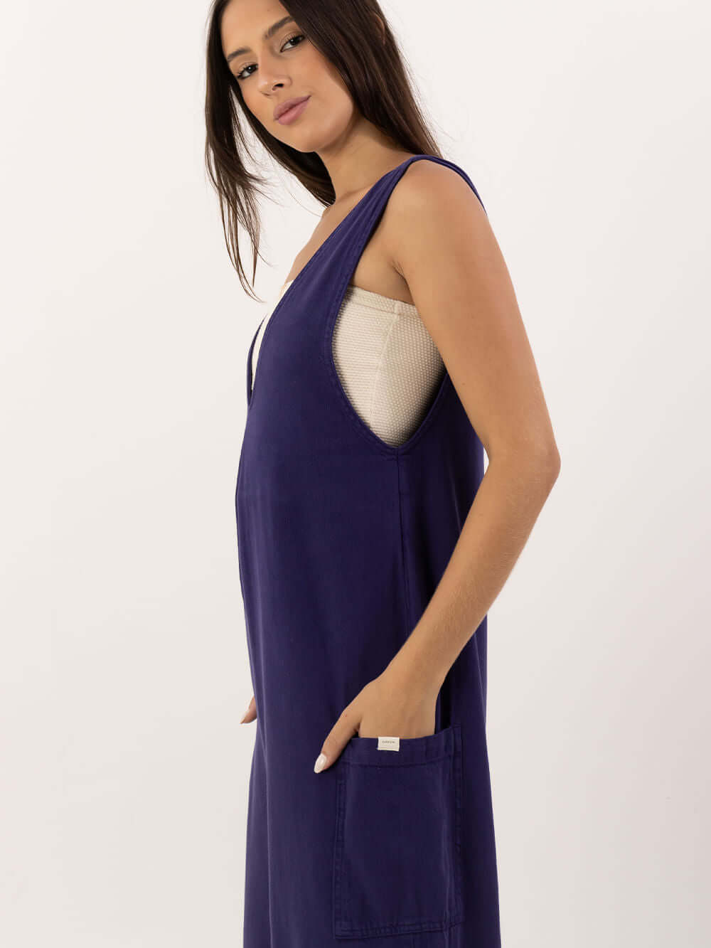 Modelo usando o Macacão Nath azul marinho da marca Greenish, destacando o design moderno e prático.