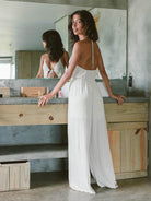 Macacão Seaside Off White da Greenish, modelagem confortável com amarração e decote em V, ideal para looks fluidos.