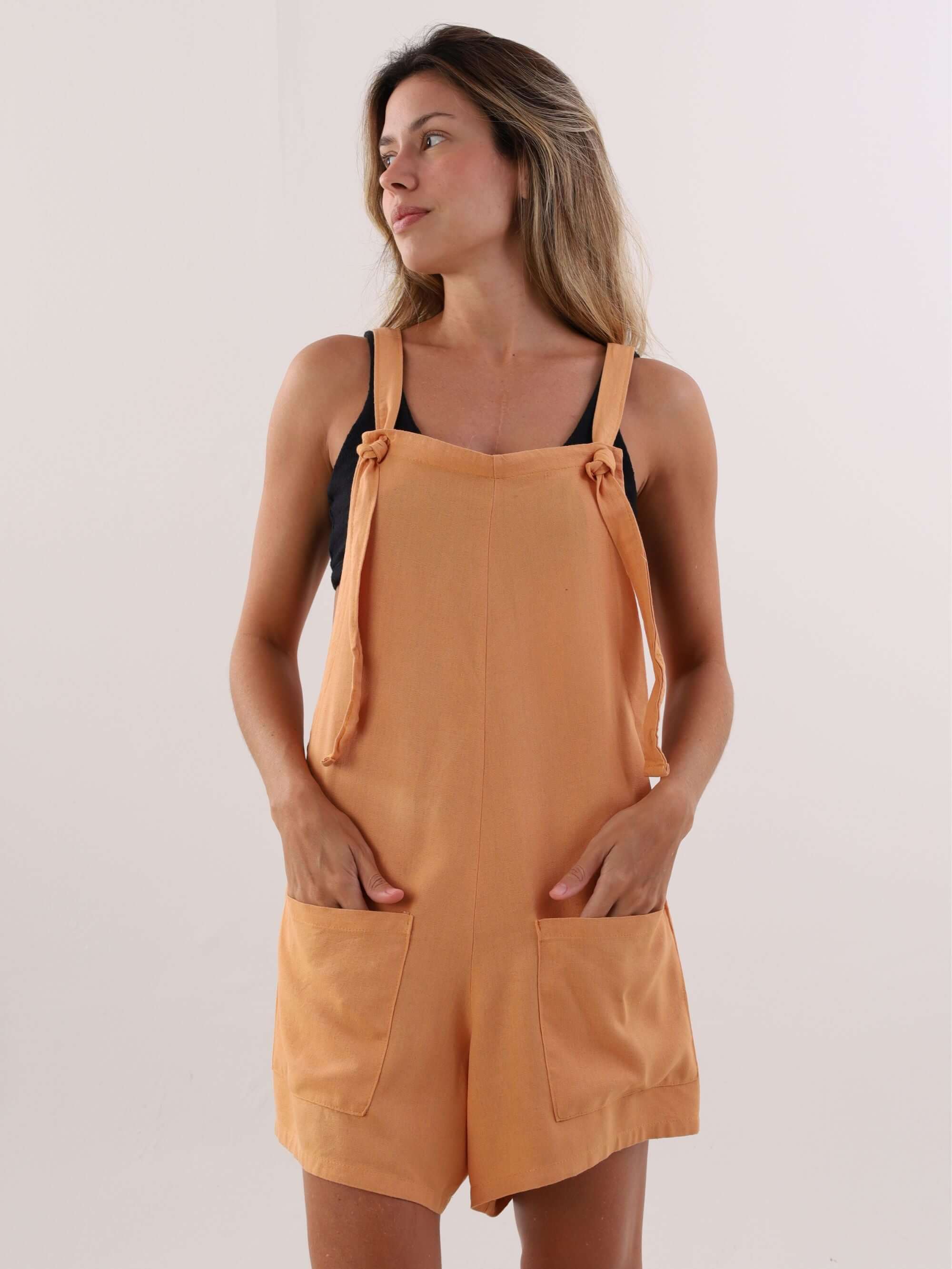 Macaquinho Quinn laranja da marca Greenish, com alças reguláveis e bolsos frontais, ideal para looks casuais.