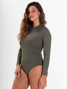 Modelo usando maiô verde Bayshore com mangas longas, destacando conforto e proteção solar.