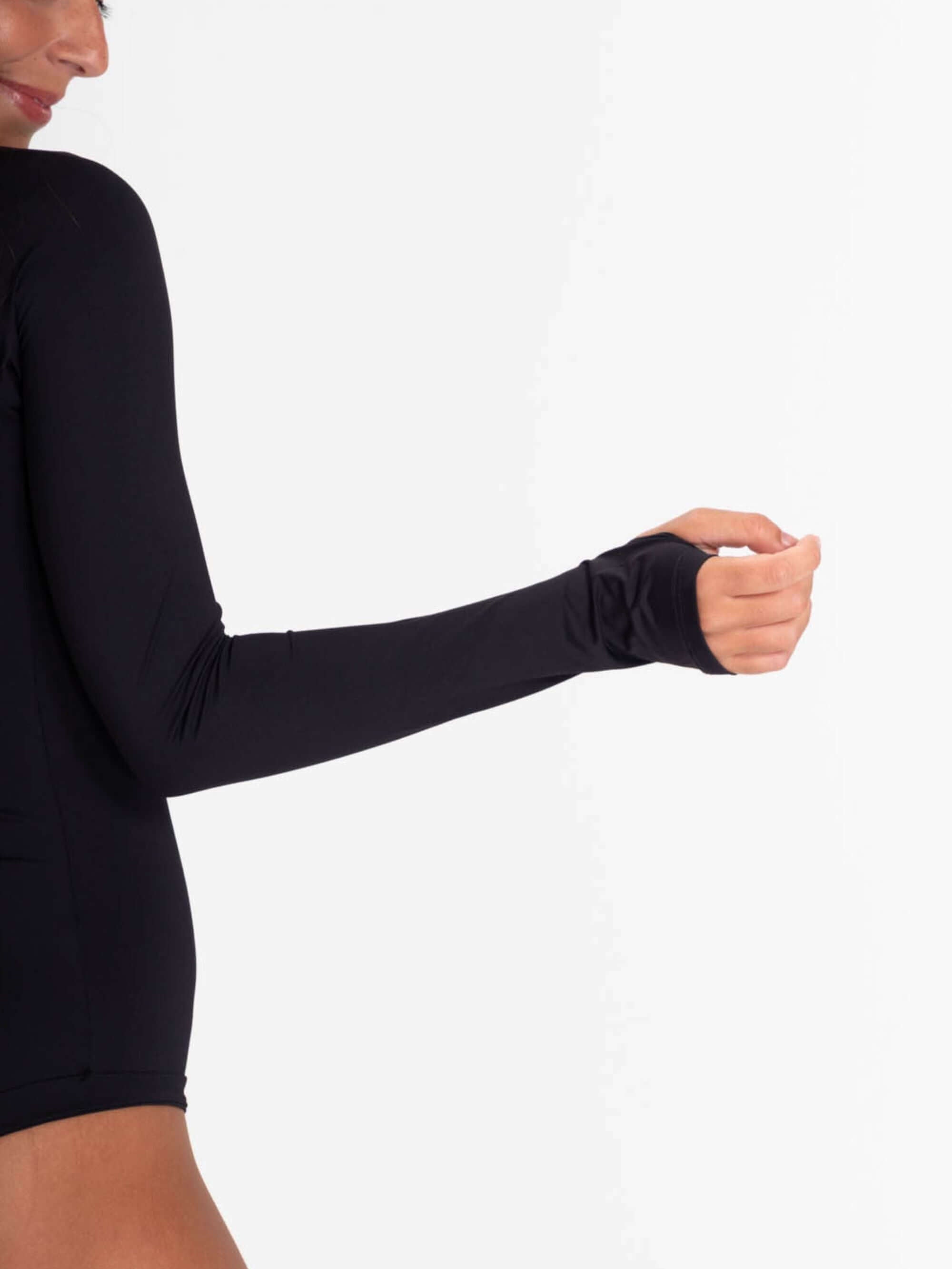 Close-up of the long sleeve black Ary swimsuit showing finger holes and flexible fabric for comfort and performance.