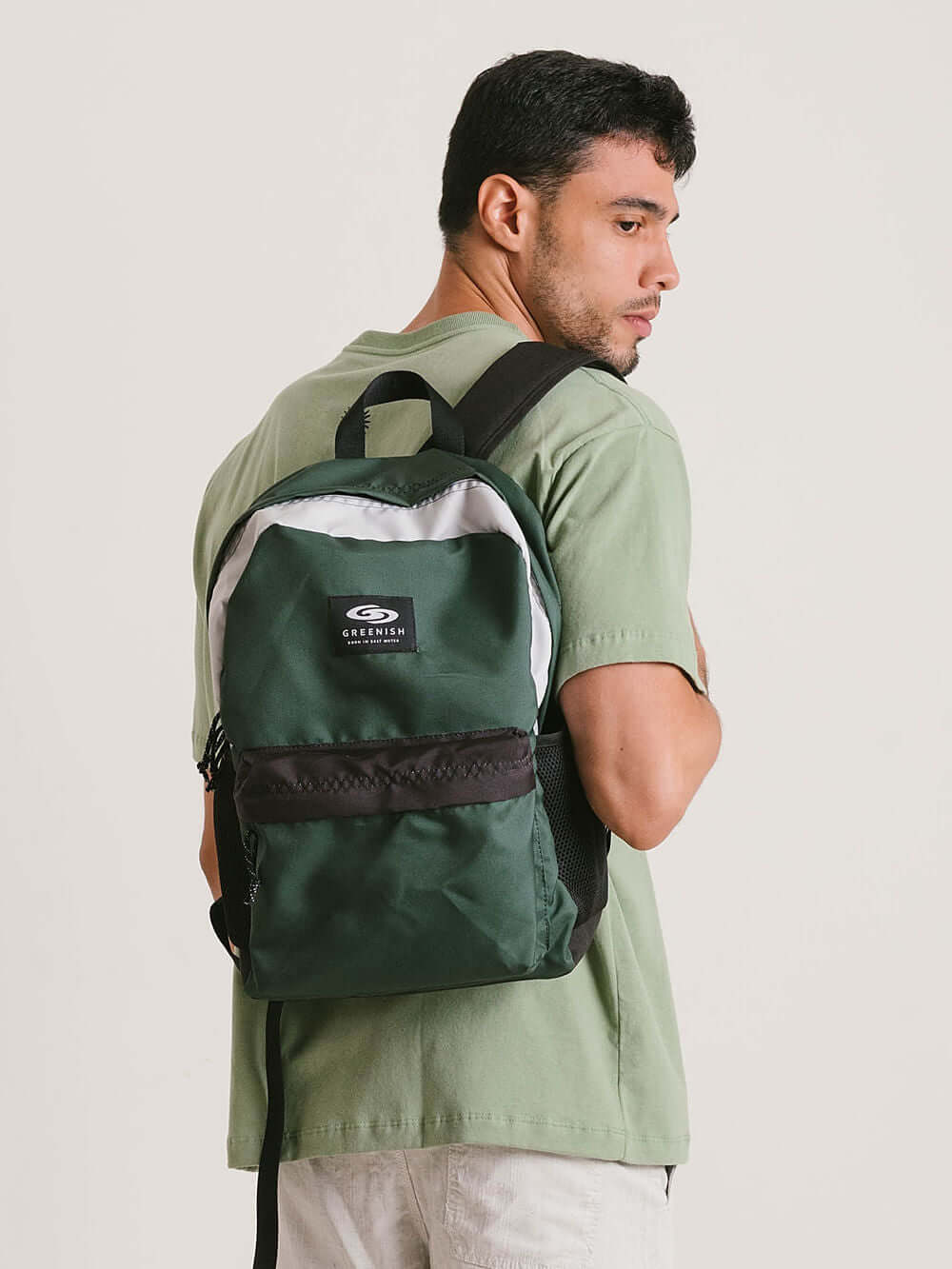 Mochila verde da Greenish, modelo MOCHILA COLORS, sendo usada por um homem, ideal para estilo e praticidade.