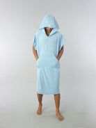 Poncho adulto azul claro da Greenish com capuz e bolso canguru, ideal para praia e esportes aquáticos.