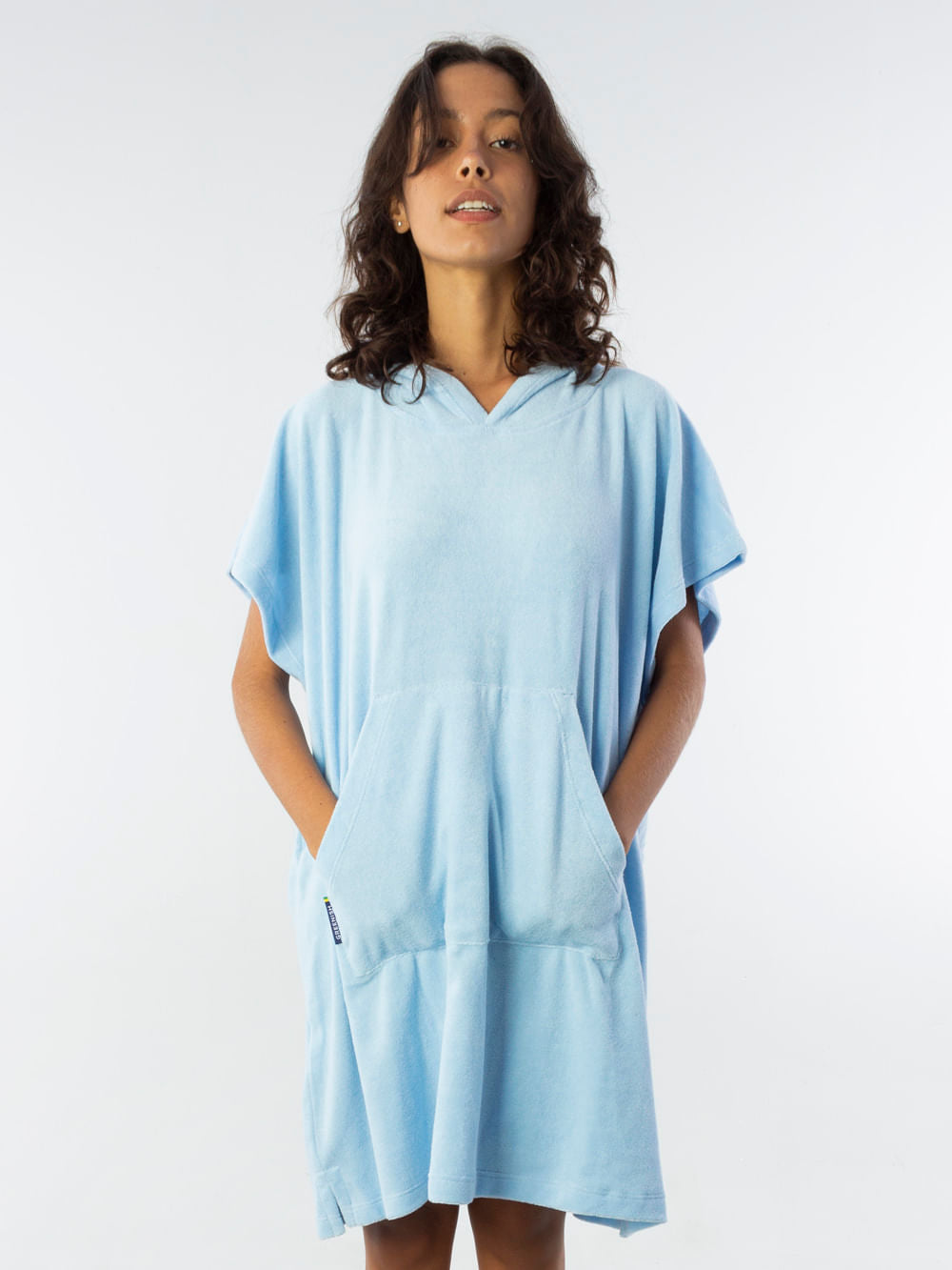 Poncho curto atoalhado azul claro com capuz e bolso frontal, ideal para praia e esportes aquáticos.