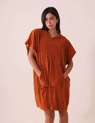 Mulher vestindo PONCHO CURTO CANELADO - CARAMELO da Greenish, destacando design casual e prático, ideal para praia e esportes aquáticos.