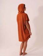 Modelo usando o PONCHO CURTO CANELADO - CARAMELO da Greenish, ideal para aquecer, trocar e proteger no esporte aquático.