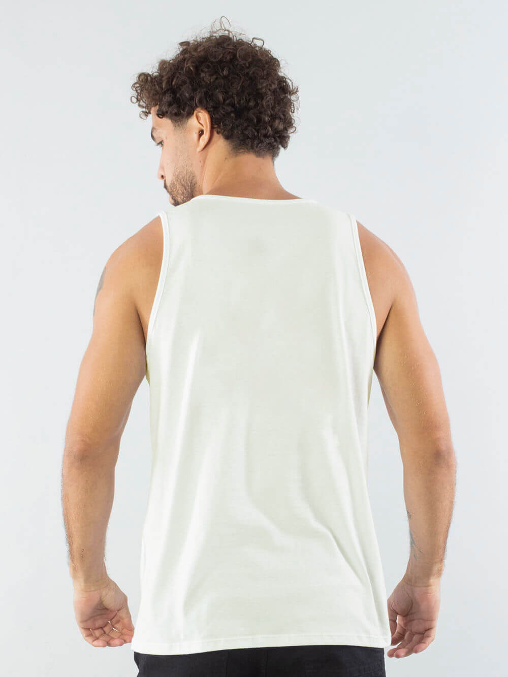 Homem usando regata off white da marca Greenish, mostrando modelagem clássica e tecido sustentável.