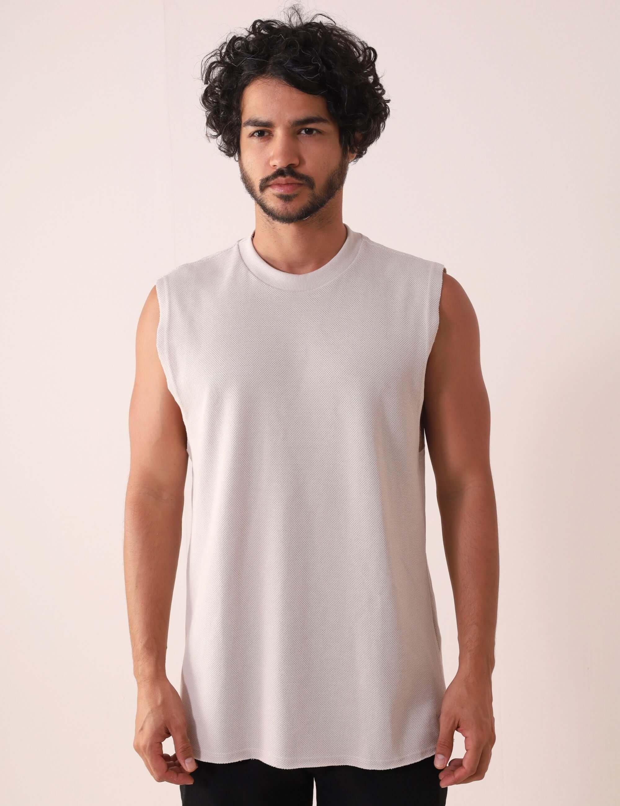 Homem vestindo Regata Larga Waves - Natural da Greenish, modelo confortável dos anos 90 com acabamento a fio e detalhe bordado elegante.