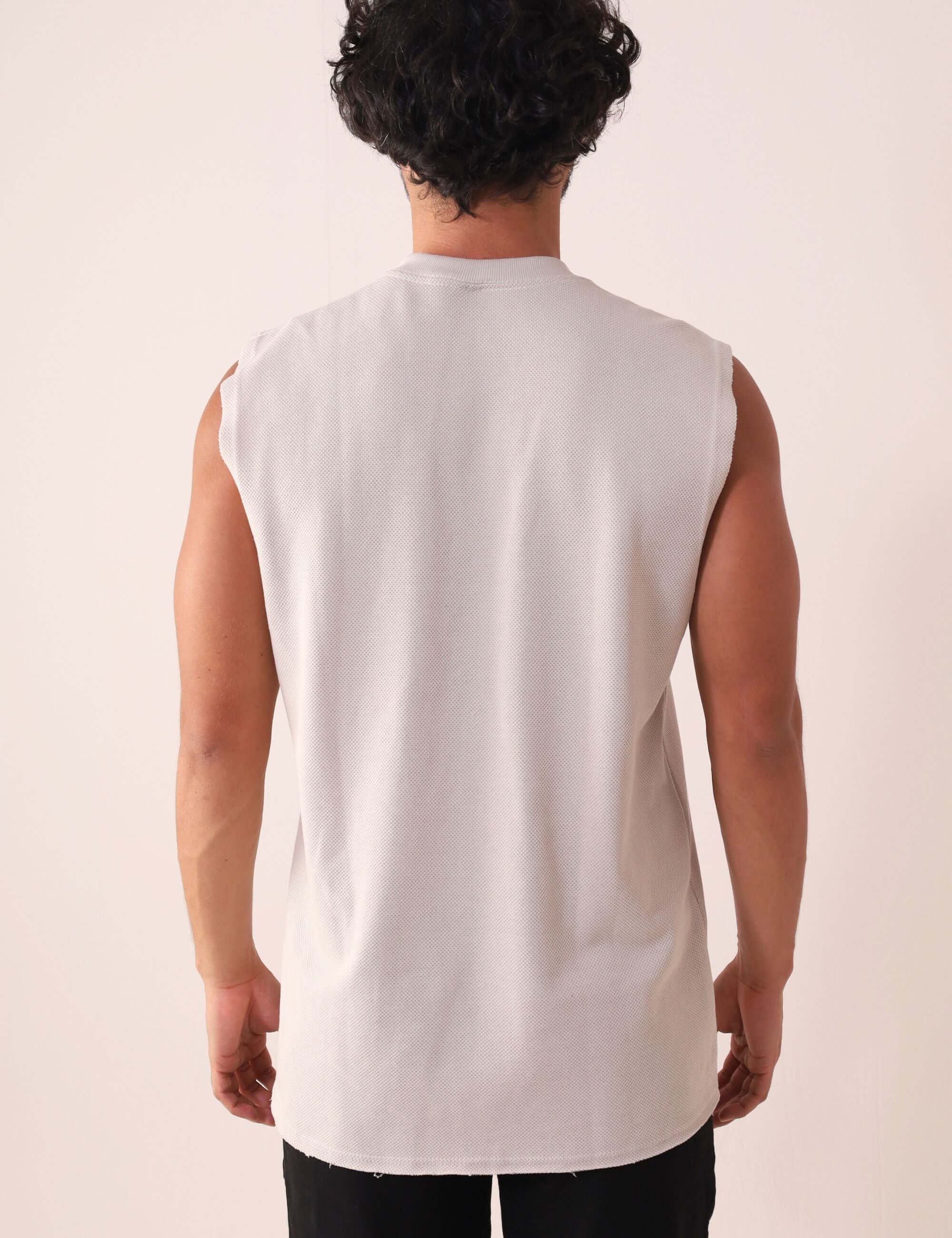 Homem vestindo REGATA LARGA WAVES - NATURAL da Greenish, modelagem larga, gola ribana, ideal para movimento. Estilo anos 90.