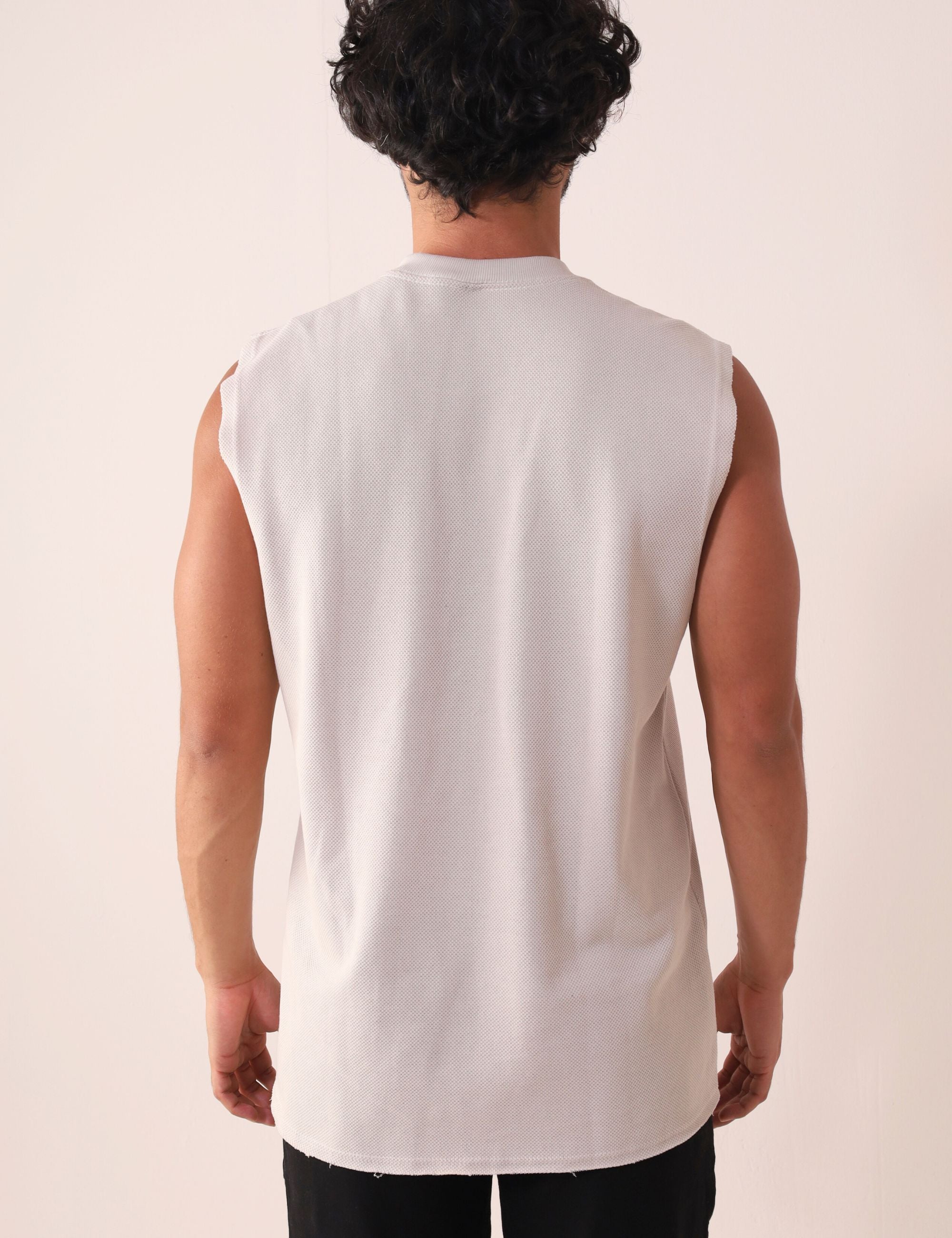 Homem vestindo REGATA LARGA WAVES - NATURAL da Greenish, modelagem larga, gola ribana, ideal para movimento. Estilo anos 90.