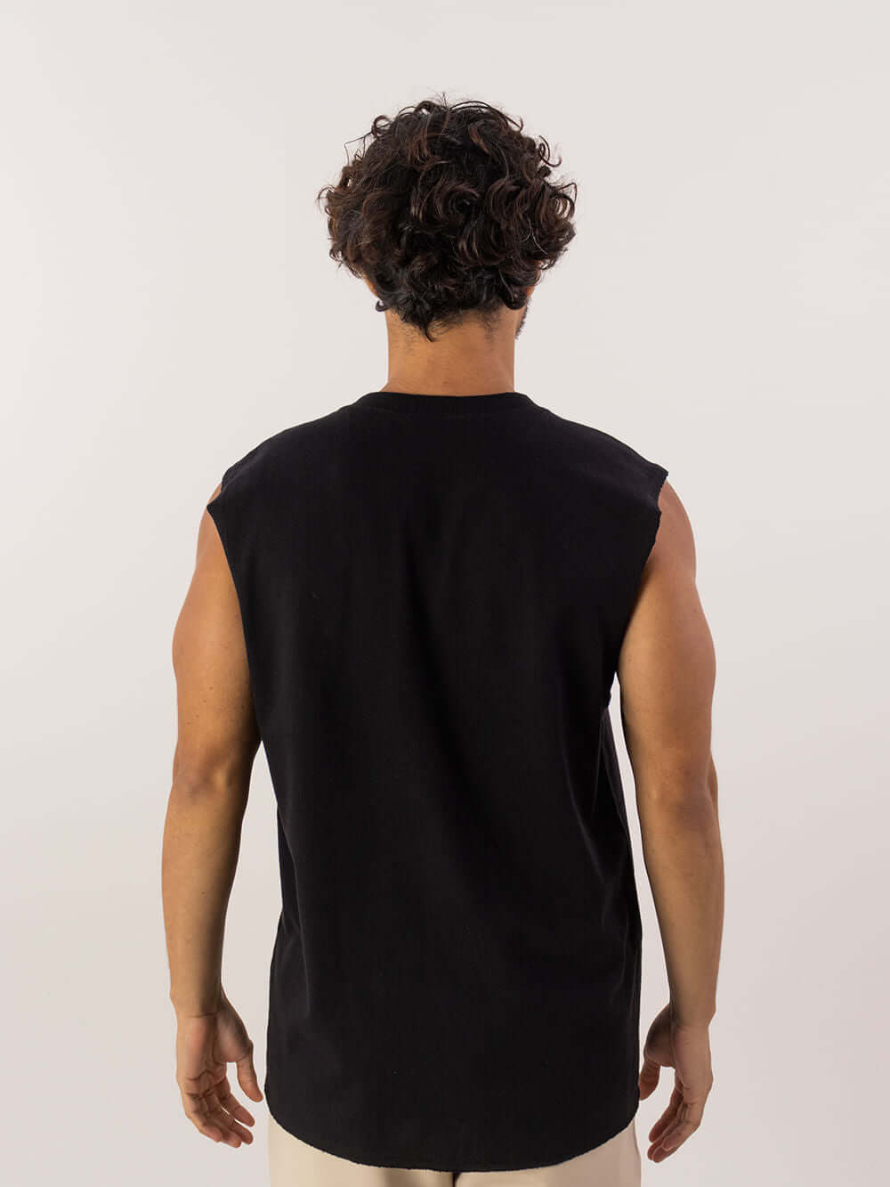 Modelo masculino usando regata longa preta da Greenish, com design confortável e cavas amplas.