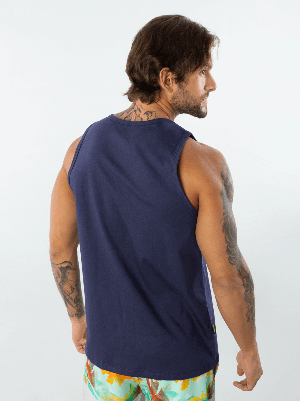 Modelo masculino usando regata malha básica azul marinho da marca Greenish, vista de costas.