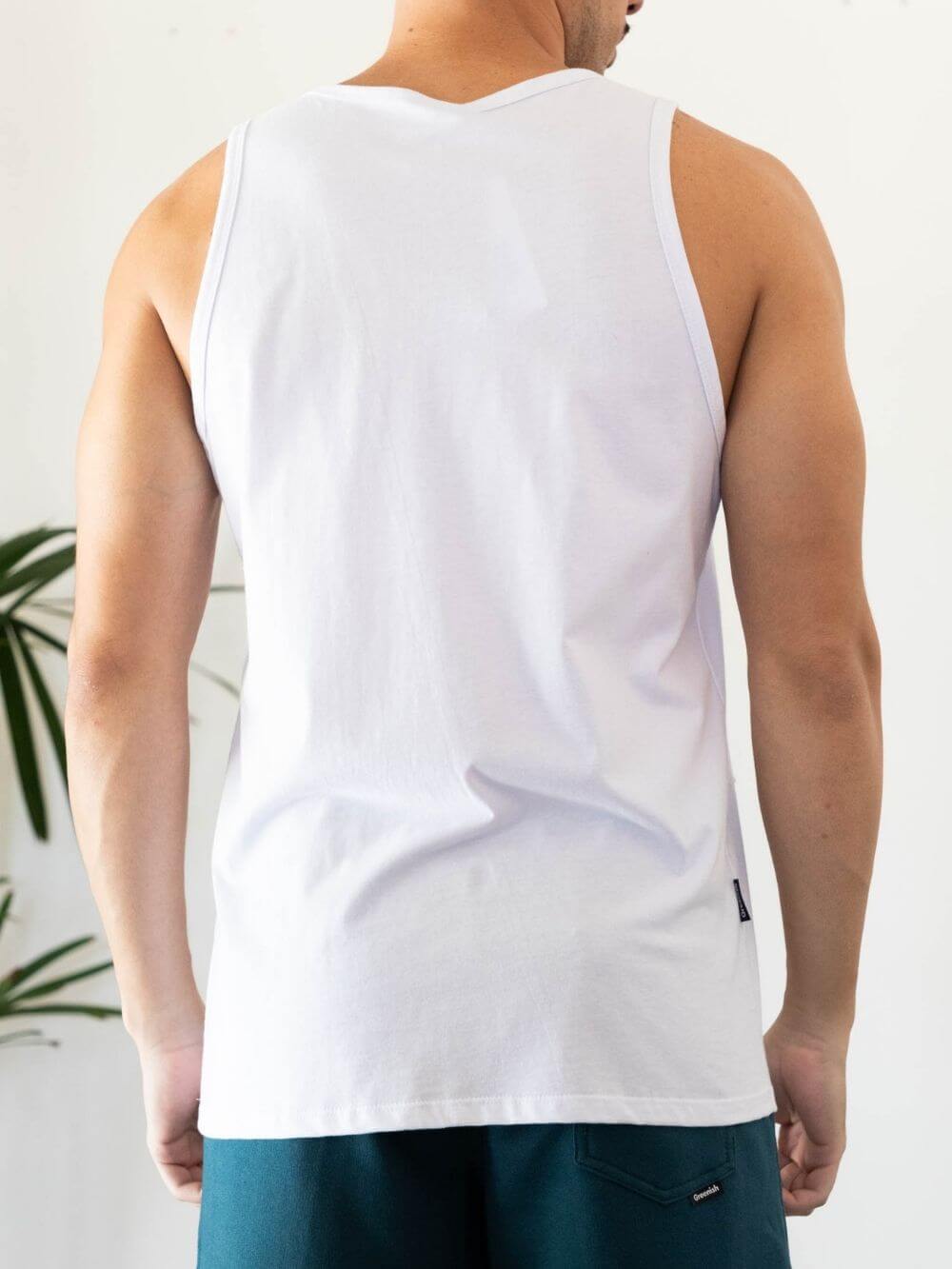 Modelo masculino vestindo regata branca malha basic da Greenish, ideal para conforto e estilo em qualquer ocasião.