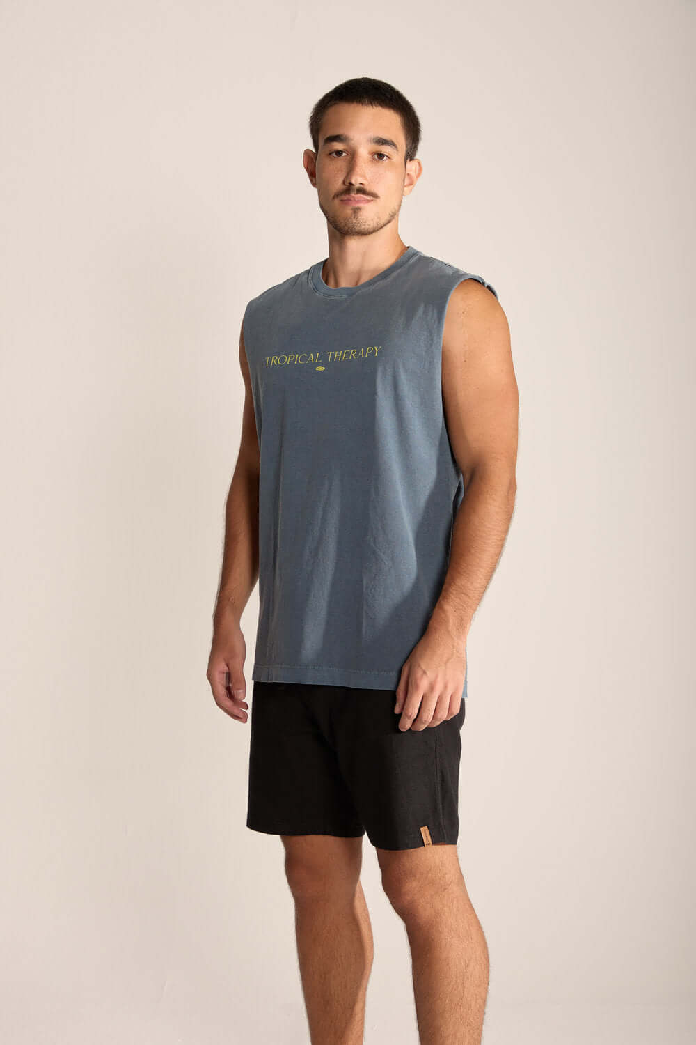 Homem usando regata masculina larga Tropical Therapy da Greenish, ideal para dias quentes e atividades ao ar livre.