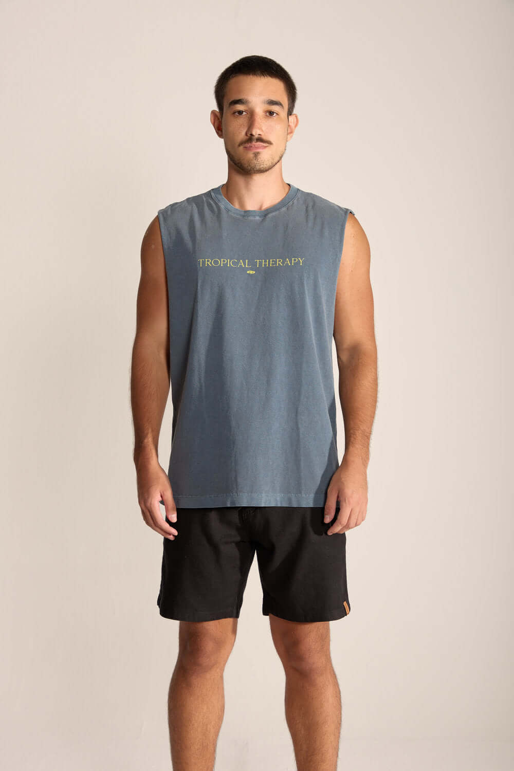 Homem usando regata larga Tropical Therapy da Greenish, ideal para dias quentes de relaxamento ao ar livre.