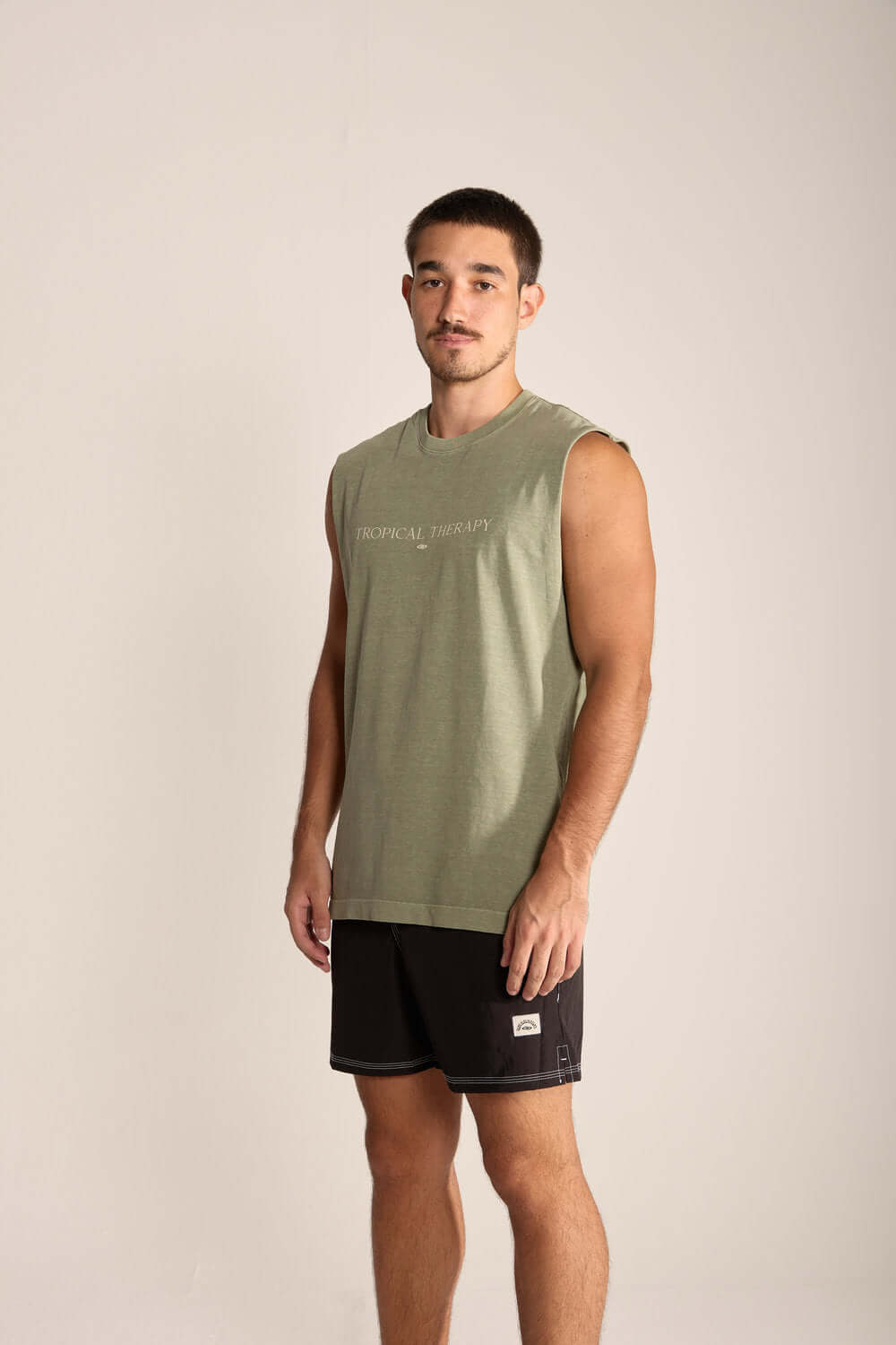 Modelo usando regata masculina larga Tropical Therapy da Greenish, cor verde, estilo casual e confortável.