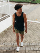 Homem usando regata ribbed azul marinho da Greenish, caminhando em espaço ao ar livre, estilo casual e confortável.