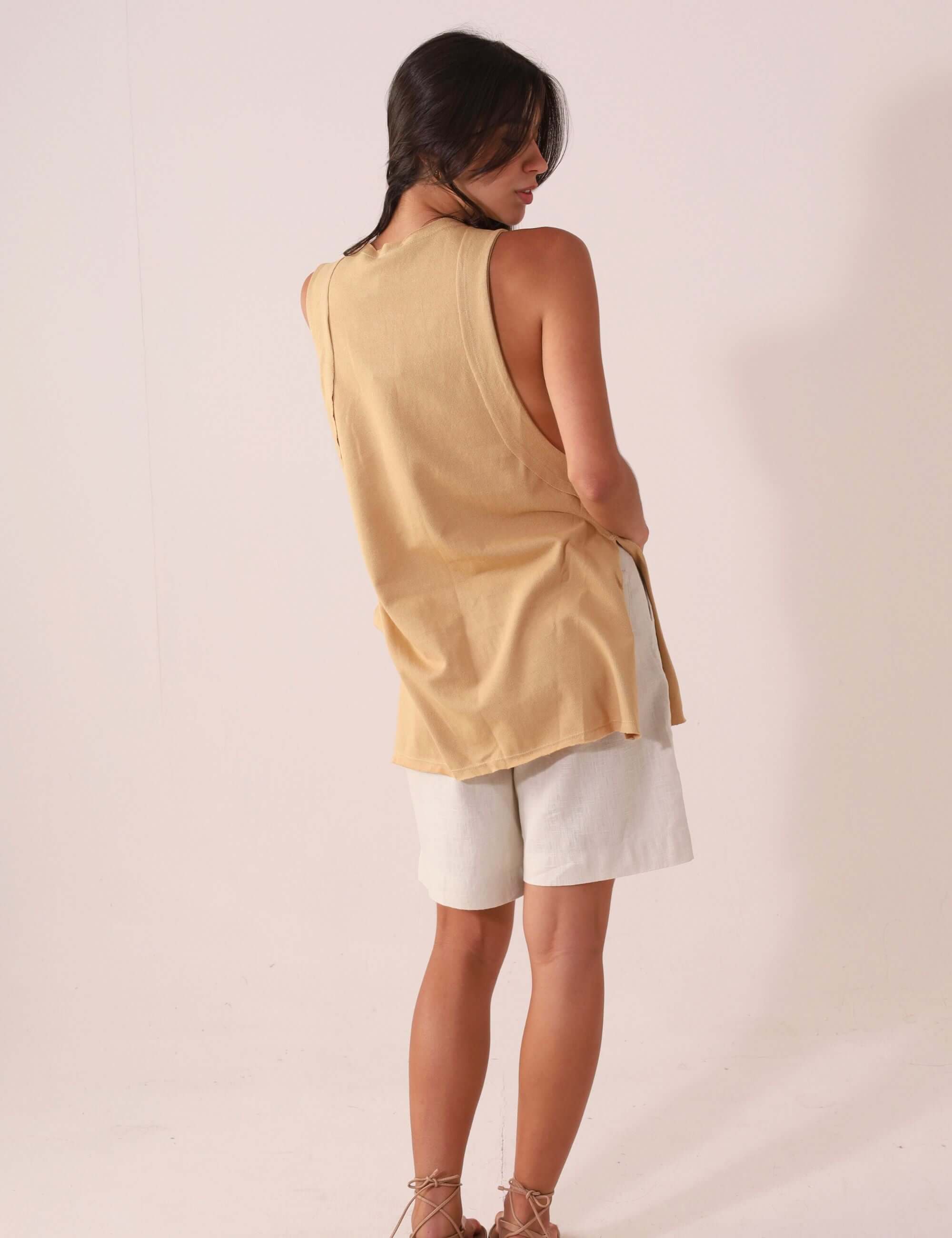 Mulher vestindo a Regata Déa - Caqui da Greenish, peça leve e confortável, ideal para looks casuais e pós-surf.