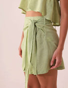 SAIA CURTA THÁ - VERDE Greenish em viscose, cintura alta, amarração lateral, visual sofisticado.