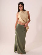 Modelo usando a SAIA MIDI DÉA - VERDE CLARO da Greenish, em malha canelada com cós elástico e fenda lateral para conforto e estilo.