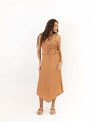 Modelo vestindo Saia Midi Lille - Bege da Greenish com visual fluido e elegante em tecido viscose enrugada com shape evasê assimétrico.