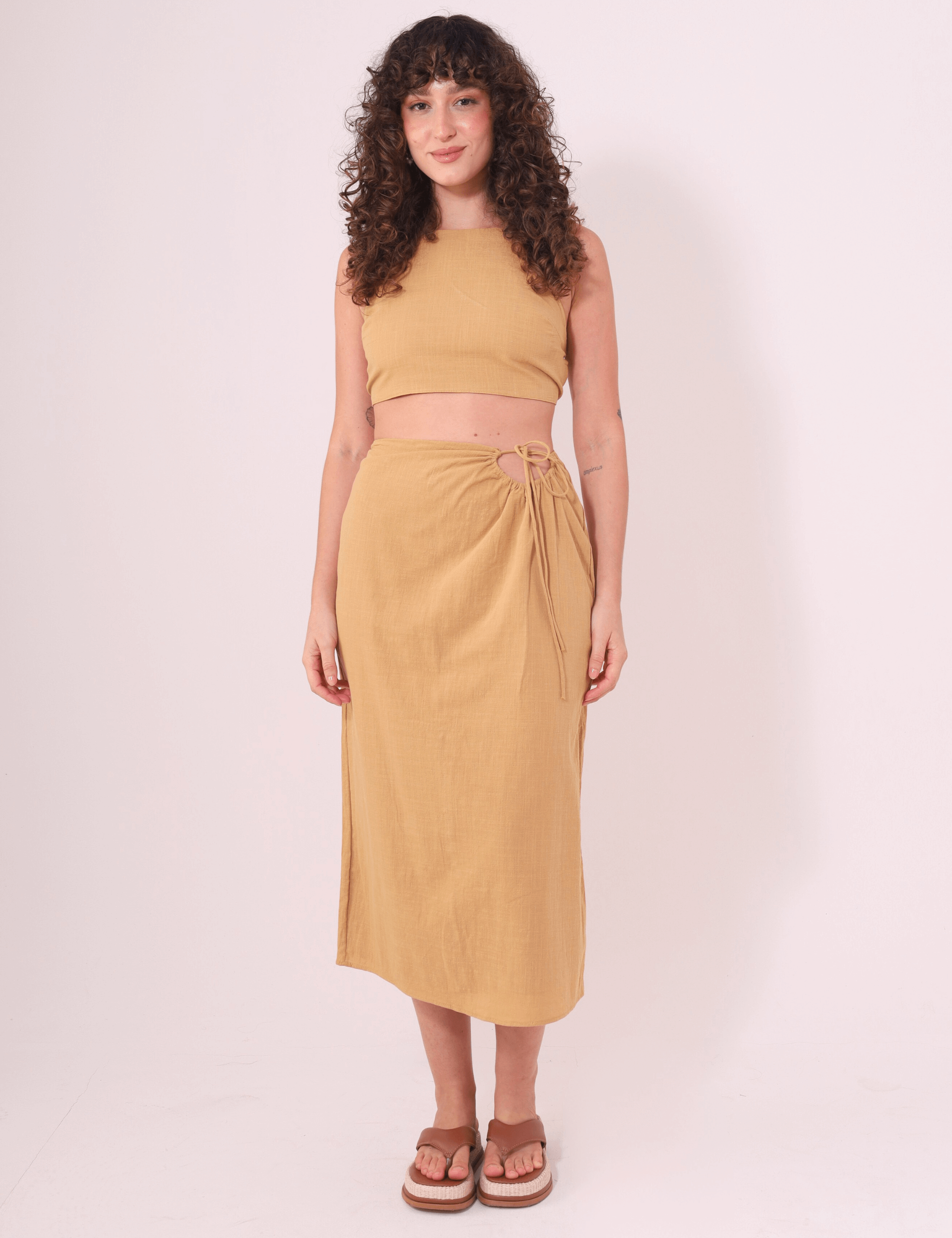 Modelo usando saia midi caqui "Sunny" da Greenish, feita em algodão e com ajuste na cintura, ideal para dias ao ar livre.