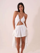 Mulher usando SHORT ÁUREA - OFF WHITE da Greenish, com caimento fluido e bolsos laterais, ideal para dias quentes, fundo branco.